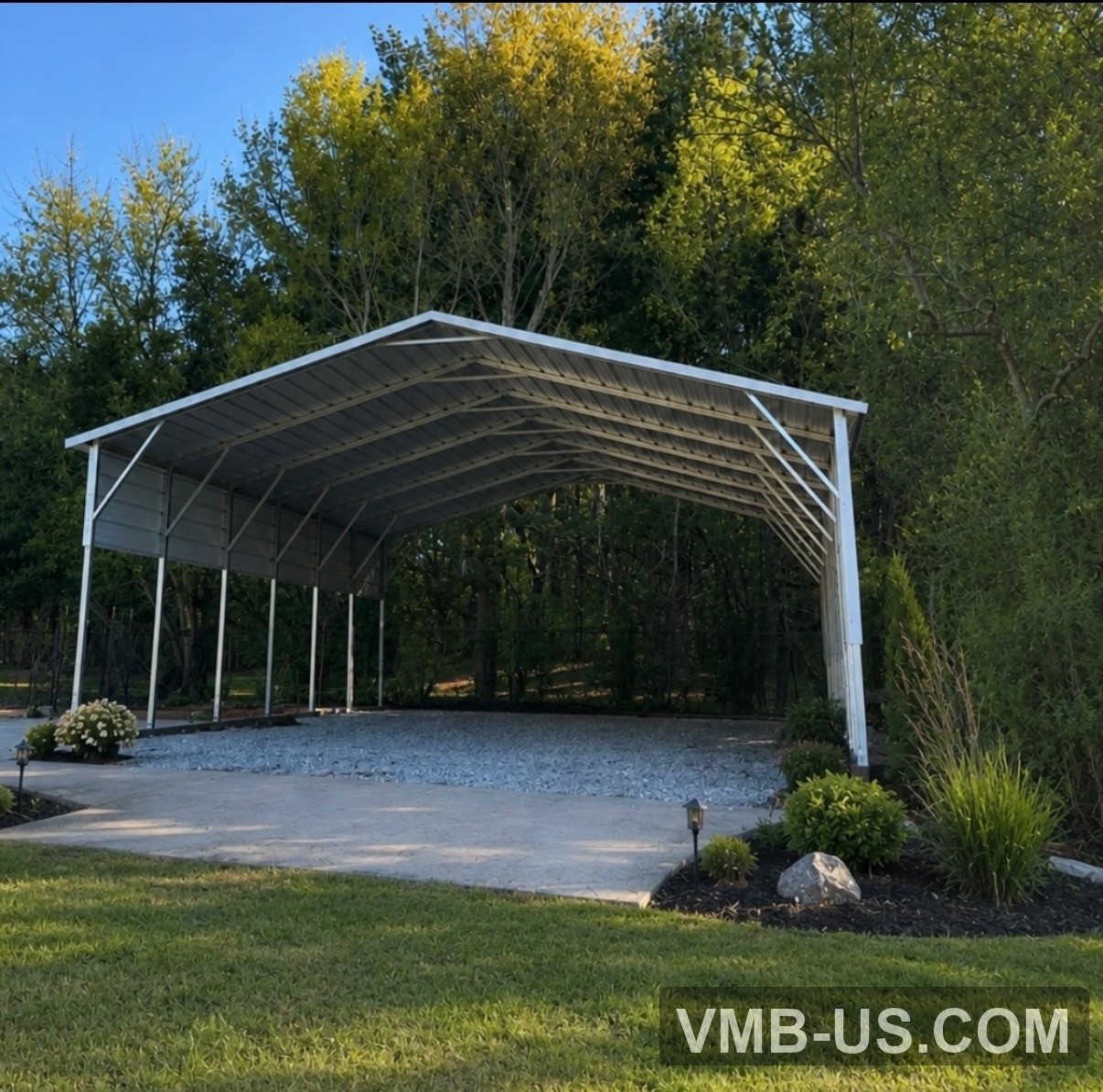 White open metal carport over a gravel pad